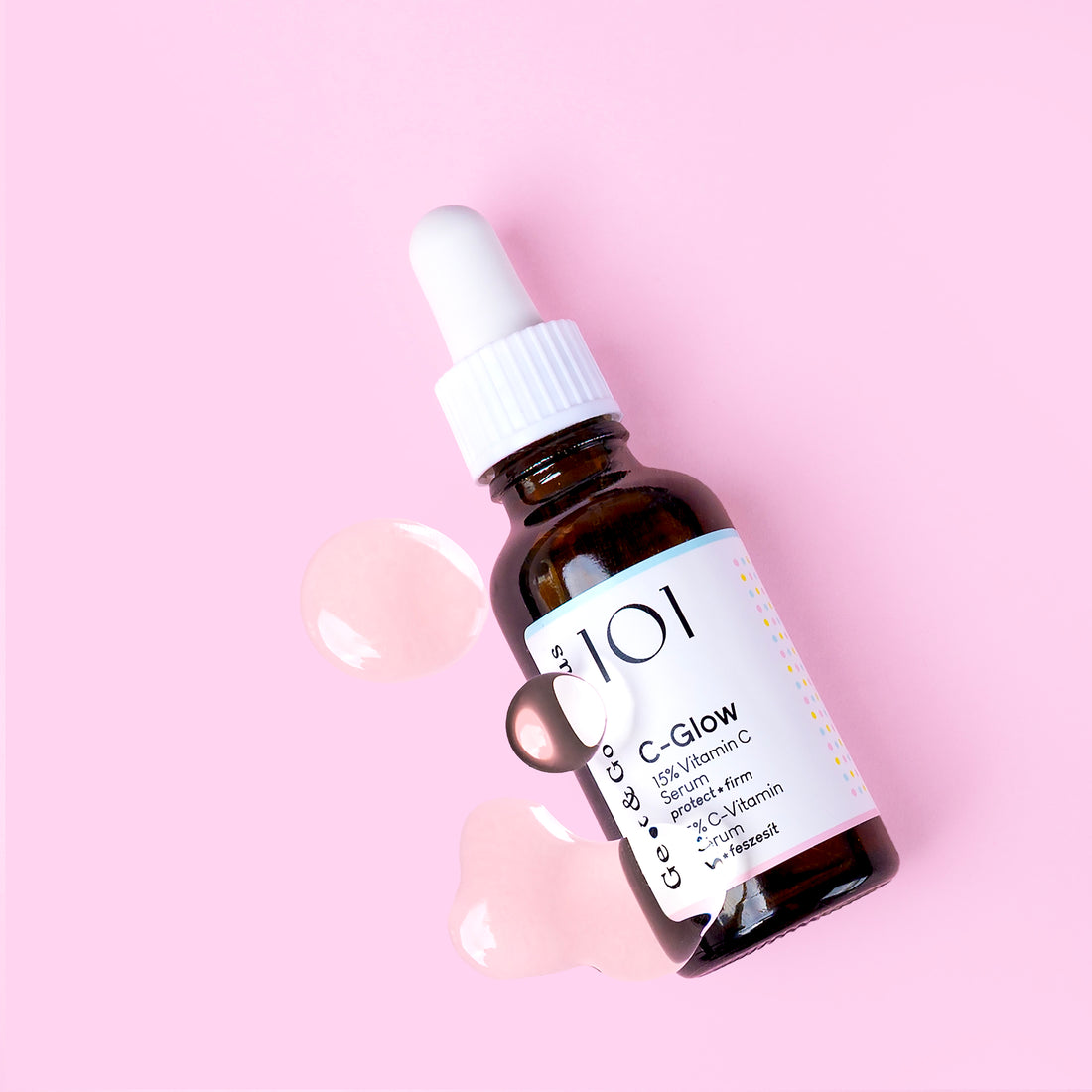 A bottle of C-Glow serum on white background. The bottle is made out of glass, and has a pipette with a rubber head.