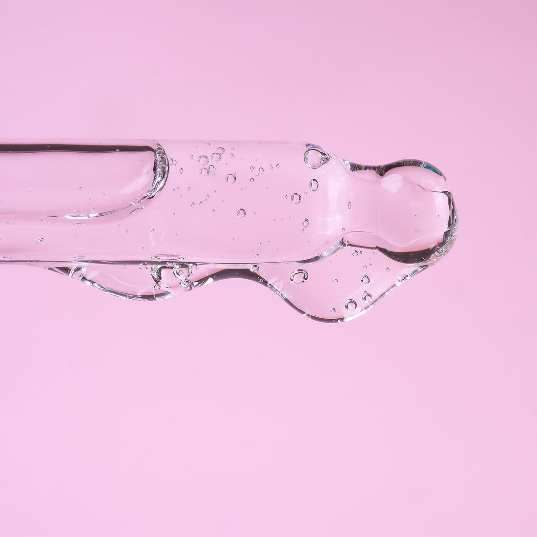 A bottle of HA5 Light serum on white background. The bottle is made out of glass, and has a pipette with a rubber head.