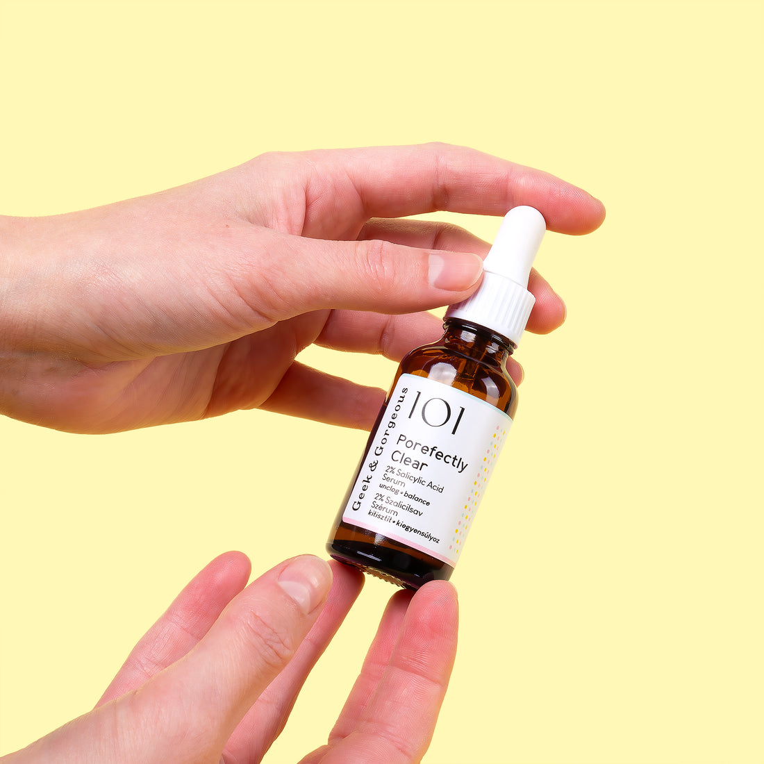 A bottle of Porefectly Clear serum on white background. The bottle is made out of glass, and has a pipette with a rubber head.